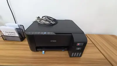 a printer sitting on top of a wooden table at Makati 2C Suite Room in Manila