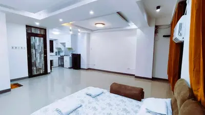 a living room with a bed and a kitchen at Makati 2C Suite Room in Manila