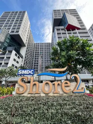 a sign for a store in front of a building at Warm Retreat with Balcony at Shore 2 Residences in Manila