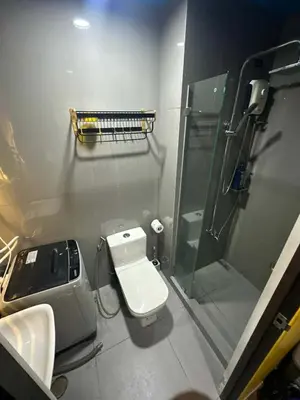 a bathroom with a toilet and a glass shower at Sunbeam - Air Residence 42nd floor in Manila