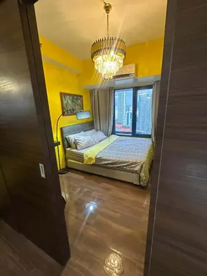 a bedroom with a bed with a window and a chandelier at Sunbeam - Air Residence 42nd floor in Manila