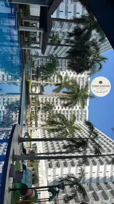 a view of a tall building with a palm tree at Shell Residences Tower A B in Manila