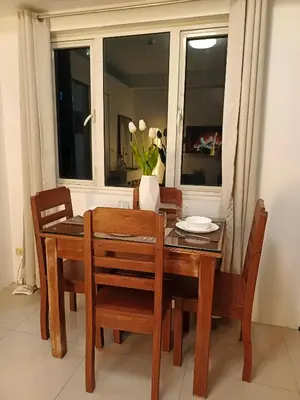 a dining room table and chairs with a window at Shore residences Yen and Yan Staycation in Manila