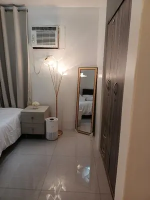a bedroom with a mirror and a bed and a dresser at Shore residences Yen and Yan Staycation in Manila