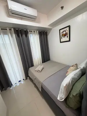 a bedroom with two beds and a air conditioner at Staycation By ABY Tower E Sea Residences in Manila
