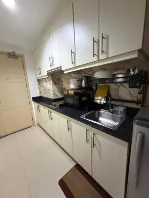 a kitchen with white cabinets and a sink at Staycation By ABY Tower E Sea Residences in Manila
