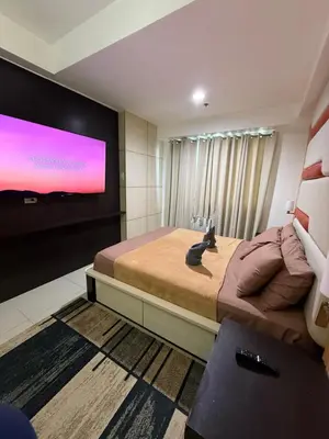 a bedroom with a large bed and a flat screen tv at Staycation By ABY Tower E Sea Residences in Manila