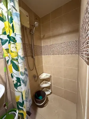 a bathroom with a shower with a toilet and a sink at Staycation By ABY Tower E Sea Residences in Manila