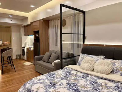 a bedroom with a bed and a couch and a kitchen at GRACE RESIDENCES Condo in Manila