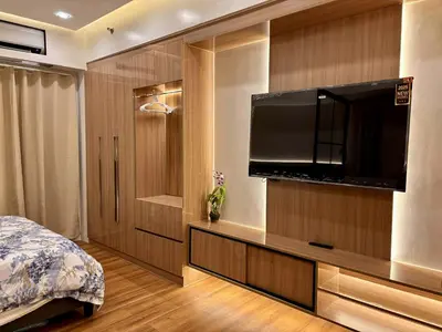a bedroom with a flat screen television on a wall at GRACE RESIDENCES Condo in Manila