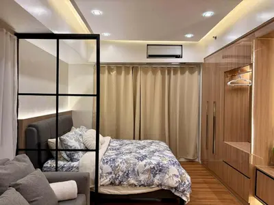 a bedroom with a bed and a couch at GRACE RESIDENCES Condo in Manila