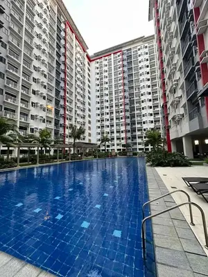 a large swimming pool in front of tall buildings at 2 BR Fully Furnished Condo in Parañaque with Pool and Parking - Bloom Unit 1133 in Manila