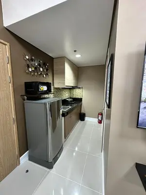 a kitchen with stainless steel appliances and a tile floor at 2 BR Fully Furnished Condo in Parañaque with Pool and Parking - Bloom Unit 1133 in Manila