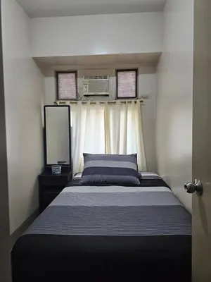 a bedroom with a bed and a television in it at Little Baguio Terraces in Manila