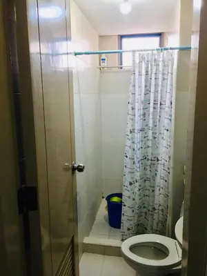 a bathroom with a toilet and a shower curtain at Little Baguio Terraces in Manila