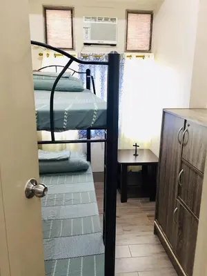 a room with two bunk beds and a table at Little Baguio Terraces in Manila