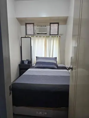 a small bedroom with a bed and a mirror at Little Baguio Terraces in Manila
