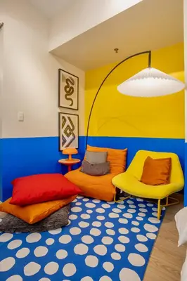 a colorful room with two beds and a rug at Modern Studio with Balcony near Ayala Makati in Manila