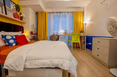 a bedroom with a bed and a desk with a chair at Modern Studio with Balcony near Ayala Makati in Manila