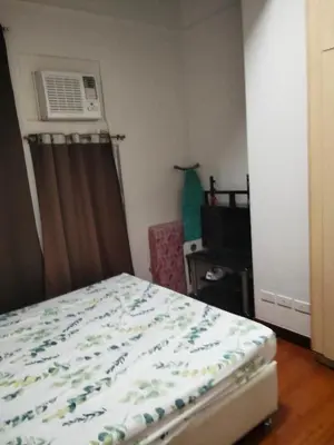 a bedroom with a bed and a air conditioner at Paseo de Roces Condominium in Manila