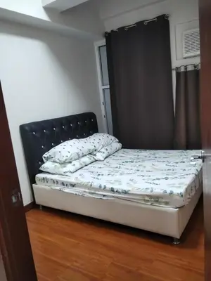 a small bed in a room with a window at Paseo de Roces Condominium in Manila