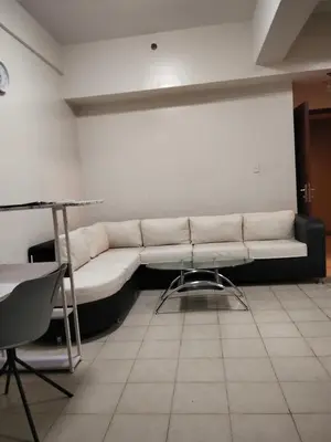 a white couch in a room with a table at Paseo de Roces Condominium in Manila