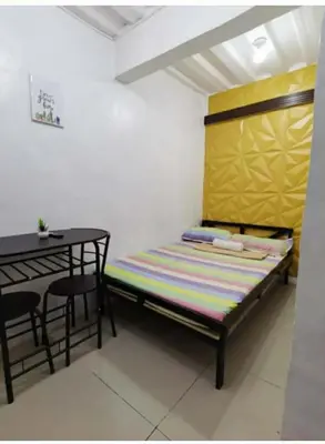 a bed in a room with a table and a bench at Transient Room for Bypackers in Imus NO CAR PARK in Imus