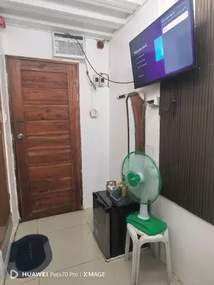 a room with a fan on a stool and a television at Transient Room for Bypackers in Imus NO CAR PARK in Imus