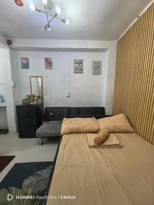 a bedroom with a large bed and a couch at Transient Room for Bypackers in Imus NO CAR PARK in Imus