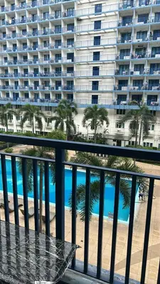 a balcony with a view of a beach and a large building at smdc condotel in Manila