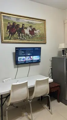 a room with a table with chairs and a picture of horses at smdc condotel in Manila