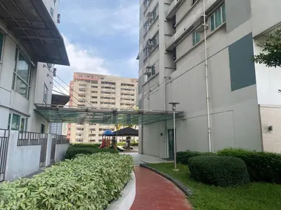 a walkway next to a tall building with bushes at 2 Bedroom Premium Condominium Beacon Makati in Manila