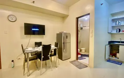 a dining room with a table and a refrigerator at 2 Bedroom Premium Condominium Beacon Makati in Manila