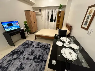 a living room with a table and a couch at Japandi Suite City Skyline View Condo Makati in Manila