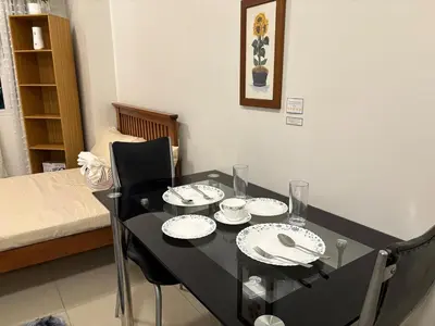 a dining room table with plates and glasses on it at Japandi Suite City Skyline View Condo Makati in Manila