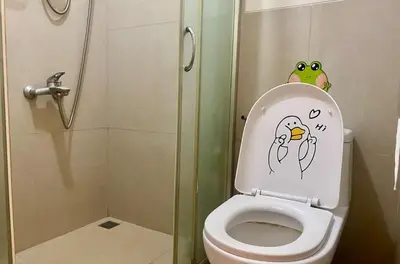 a bathroom with a toilet with a frog on the lid at Japandi Suite City Skyline View Condo Makati in Manila