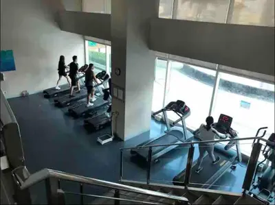 a group of people running on treadmills in a gym at Japandi Suite City Skyline View Condo Makati in Manila