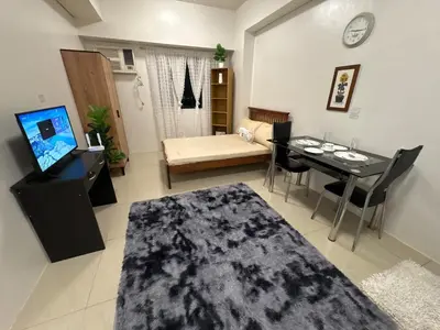 a living room with a table and a dining room at Japandi Suite City Skyline View Condo Makati in Manila