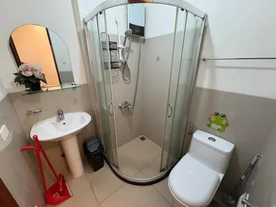 a bathroom with a shower and a toilet and a sink at Japandi Suite City Skyline View Condo Makati in Manila