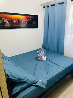 a bed with blue sheets and a cup on it at ESY Condotel shore 1-B in Manila