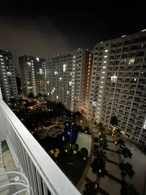 a view from a balcony of a building at night at AC Haven in Shore Residences near MOA Pasay City in Manila