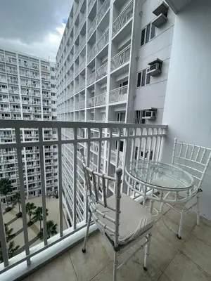 a balcony with a table and chairs and a building at AC Haven in Shore Residences near MOA Pasay City in Manila