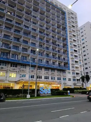 a large building with a sea sign in front of it at The Barn at Sea Residences in Manila