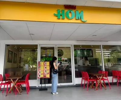 a woman standing in front of a store at The Barn at Sea Residences in Manila