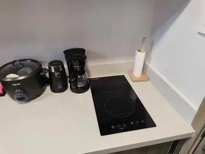 a kitchen counter with a stove and appliances on it at The Place To Be with Balcony and Kitchen Mandaluyong in Manila