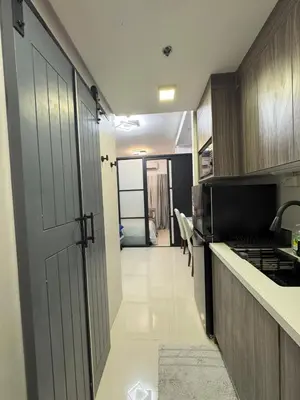 a kitchen with a door leading to a hallway at The Place To Be with Balcony and Kitchen Mandaluyong in Manila