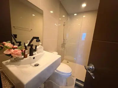 a bathroom with a sink and a toilet and a shower at The Ellis Luxe Suites in Manila