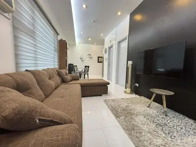 a living room with a couch and a flat screen tv at 8 Adriatico Condominium in Manila