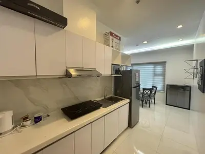 a kitchen with white cabinets and a black refrigerator at 8 Adriatico Condominium in Manila