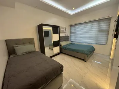 a bedroom with two beds and a mirror at 8 Adriatico Condominium in Manila